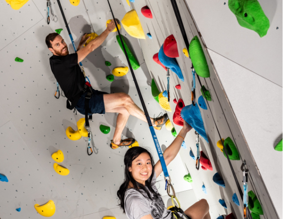Student and teacher indoor rock climbing
