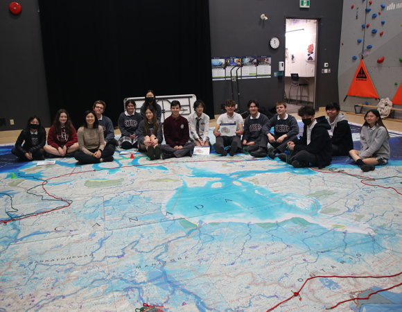 Students sitting around a world map