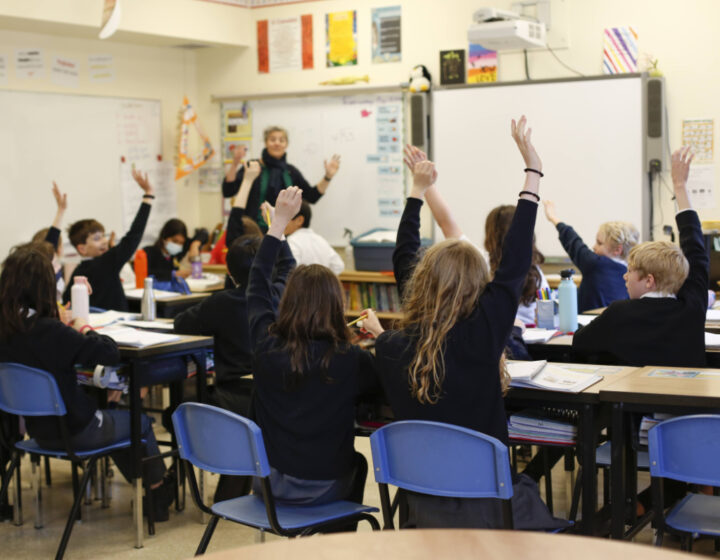 Students raising their hands to answer a question