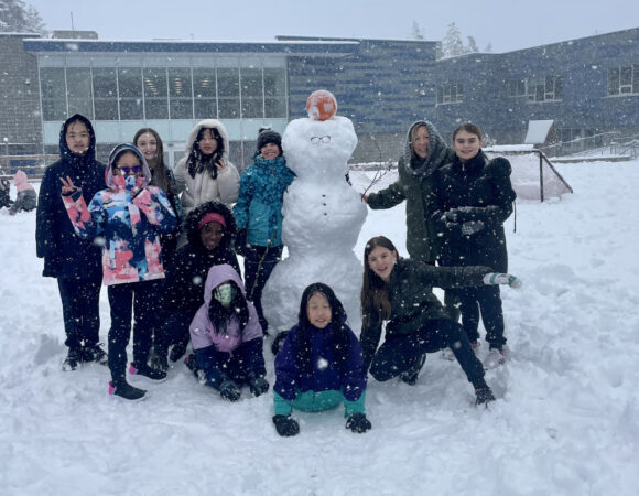 WCRA students posing next to a snow man